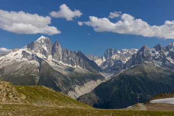 The Petit Dru mountain summit displays rugged peaks and rocky formations against clear sky. Rocky...