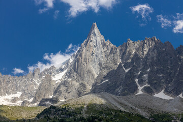 The Petit Dru mountain summit displays rugged peaks and rocky formations against clear sky. Rocky peak of Aiguilles de Dru, les Drus in Chamonix Alps