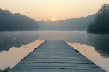 Fototapeta premium Sunrise over a serene lake with a wooden pier surrounded by mist and autumn leaves