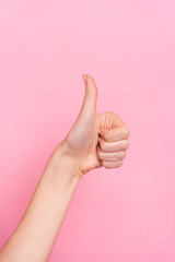 Vertical cropped view of attractive girl hand showing thumbup ad cool solution yes isolated over pink pastel color background