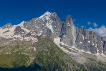 The Petit Dru mountain summit displays rugged peaks and rocky formations against clear sky. Rocky...