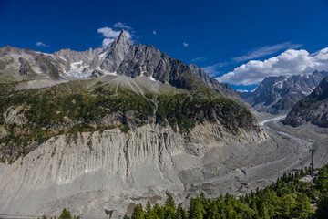 The Petit Dru mountain summit displays rugged peaks and rocky formations against clear sky. Rocky...