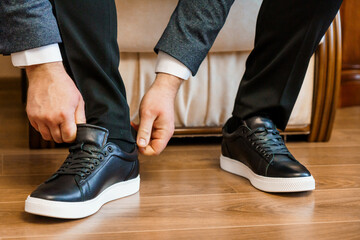 Stylish Man Adjusting His Pants While Wearing Black Sneakers