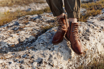 On top of the world person standing on rock in stylish leather combat boots for travel and adventure concept