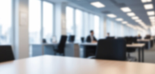 A modern office interior featuring empty desks and chairs, with blurred background elements creating a bokeh effect.