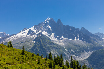 The Petit Dru mountain summit displays rugged peaks and rocky formations against clear sky. Rocky...