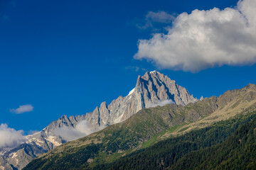 The Petit Dru mountain summit displays rugged peaks and rocky formations against clear sky. Rocky...