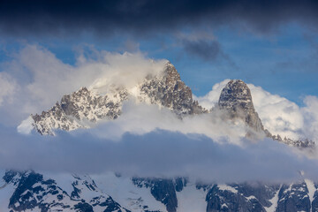 The Petit Dru mountain summit displays rugged peaks and rocky formations against clear sky. Rocky...
