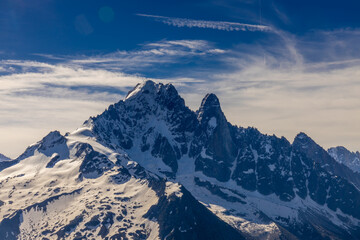 The Petit Dru mountain summit displays rugged peaks and rocky formations against clear sky. Rocky...