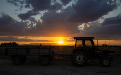 magnificent sunset and tractor view in agricultural field