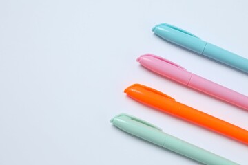 Pastel coloured pens on white backgroung, top view
