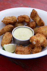 Top view of fried breaded shrimps with avocado mayonnaise and lemon.