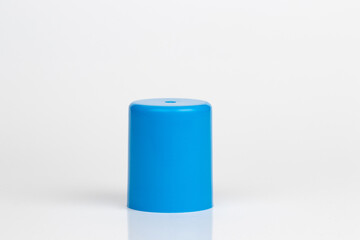 Cyan plastic cylindrical cap, cylinder shaped object, solid side up, isolated on white background.