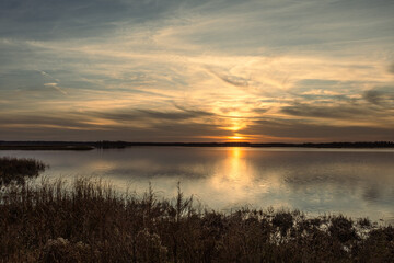 a beautiful landscape as the sun sets and reflects on the blue water of a lake