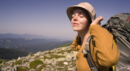 A young girl travels, is engaged in active sports, climbs with trekking poles in atmospheric weather,