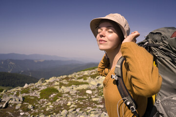 A young girl travels, is engaged in active sports, climbs with trekking poles in atmospheric weather,