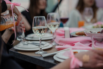 Elegant Dining Experience with Reflections in Glassware and Soft Pink Accents