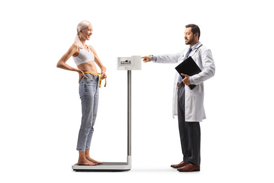 Doctor measuring underweight female patient on a scale
