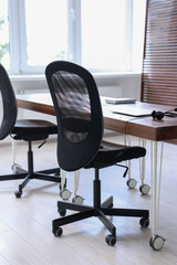 Black chairs, laptop and desk in office