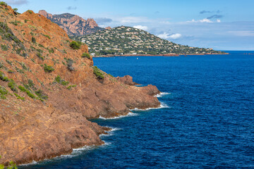 Red rocks illuminated by the sun fall into the Azure Sea - Provence, France