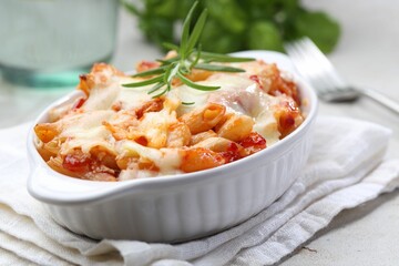 Delicious al forno pasta in baking dish on light table, closeup
