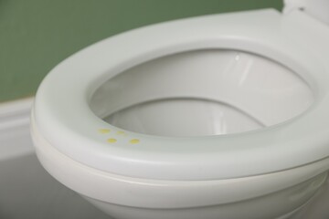 Urine drops on toilet seat in restroom, closeup
