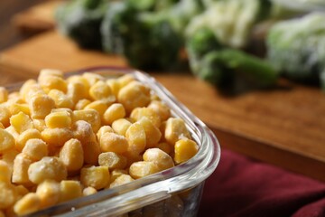 Frozen corn kernels in glass container on table, closeup