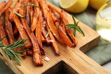 Delicious sweet potato fries with spices on table, closeup