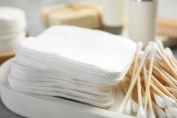 Clean cotton pads and swabs on grey table, closeup