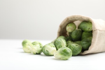 Fresh Brussels sprouts in bag on white table, closeup
