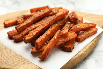 Delicious sweet potato fries with spices on table, closeup