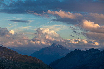 Obraz premium Sunset burning red and orange sky above the snow summits and rocky peaks of the Alps. Beautiful mountain sunset and sunrise in Chamonix valley on the ascent to Montblanc