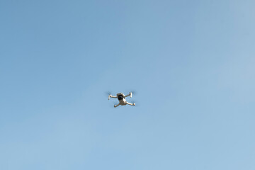 The drone flies against the blue sky	