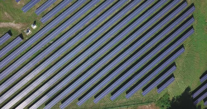 Solar panel array field from above drone shot putting power back into the energy grid on a sunshine day. Sustainable resources and renewable energy, Vermont, USA
