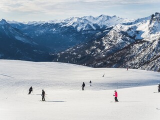 Skiers on snowy mountain slope with scenic landscape