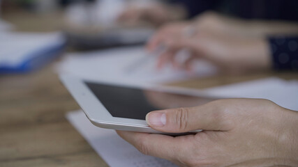 Accountants or auditors reviewing financial documents while sitting at the wooden desk in office. Professionals analyzing paper reports and using calculators, close up. Audit and taxes concept
