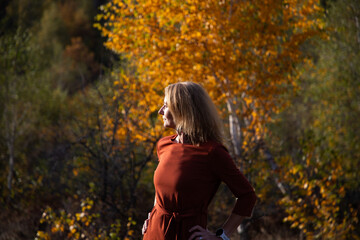 woman with happy white dog in autumn landscape