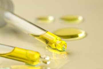 Cosmetic oil and pipettes on dark beige background, closeup