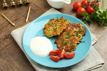 Delicious potato pancakes, menorah and candles on wooden table, closeup. Hanukkah festive food