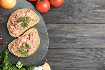 Sandwiches with canned meat served on wooden table, top view. Space for text