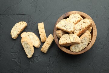 Traditional Italian almond biscuits (Cantucci) in bowl on black table, top view