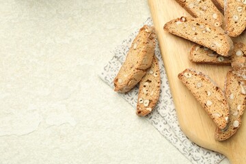 Traditional Italian almond biscuits (Cantucci) on light textured table, flat lay. Space for text