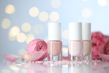 Nail polishes in bottles, beads and beautiful flowers on white table, closeup. Space for text