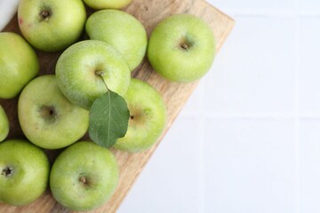 Fresh ripe green apples on white tiled table, top view. Space for text