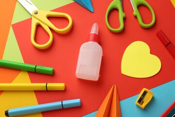 Flat lay composition with glue, scissors and other stationery on color background