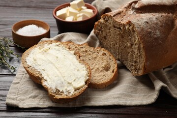 Fresh bread with butter on wooden table, closeup