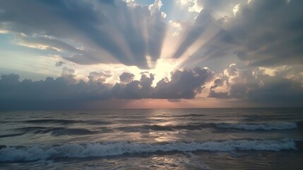 A dramatic sky over the ocean, with sunbeams piercing through heavy clouds