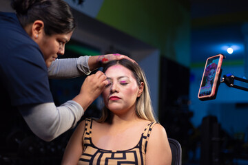 Woman painting details on her Catrina makeup for Day of the Dead.