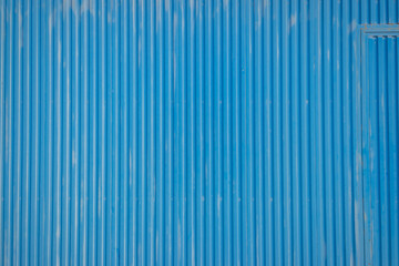 detail of a blue corrugated metal door from a warehouse, textured background