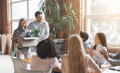Friendly young multiracial business team welcoming girl in hijab new employee, manager introducing...